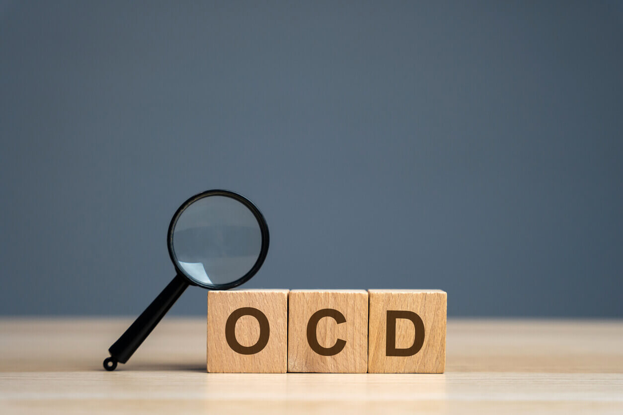 Image of wooden blocks with the abbreviation OCD and a magnifier to symbolize the search for an OCD specialist.