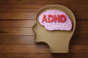 ADHD is written in red letters and placed on a brain image.